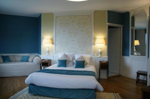 une chambre avec un grand lit et un canapé dans l'établissement Le Clos Saint-Gilles, à Ardevon