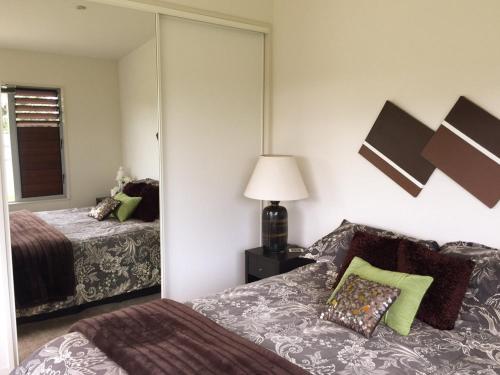 ein Hotelzimmer mit zwei Betten und einem Spiegel in der Unterkunft City lights, Jewel in the Crown, Waiheke Island in Waiheke Island