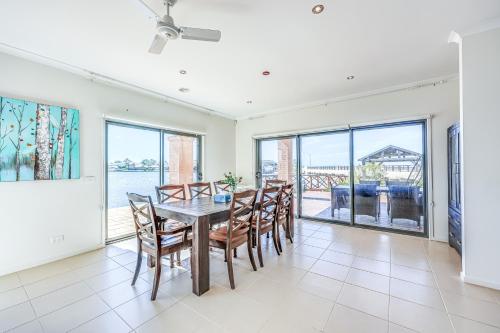 a dining room with a table and chairs at StayAU 5BR Idyllic Lakefront Escape Point Cook in Point Cook