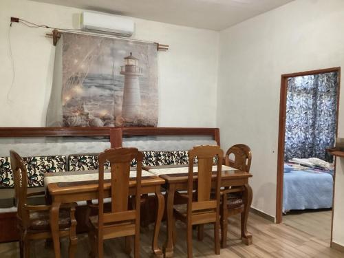 a dining room with a table and chairs and a lighthouse picture at Vientos de magia in La Esperanza
