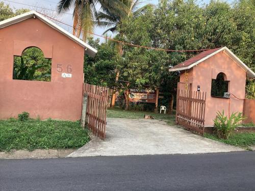 a small pink house with a fence and a driveway at Vientos de magia in La Esperanza