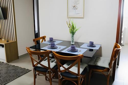 a dining room with a black table and chairs at Apartamento prox. Ponte da Amizade para 4 pessoas com Ar in Foz do Iguaçu