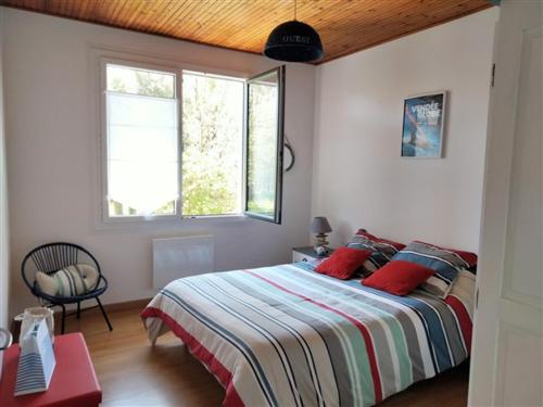 une chambre avec un grand lit avec des oreillers rouges dans l'établissement Maison familiale avec jardin, parking privé et wifi aux Sables-d'Olonne - FR-1-331-35, à Les Sables-dʼOlonne
