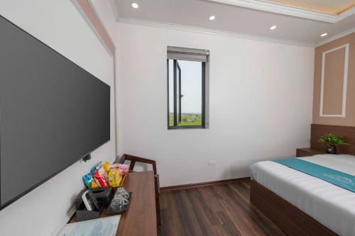 a bedroom with a bed and a table and a window at Airport Classic Hotel 2 in Sóc Sơn