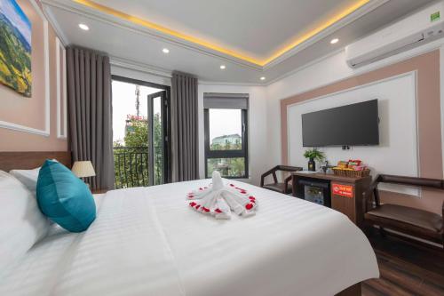 a bedroom with a large white bed with a flat screen tv at Airport Classic Hotel 2 in Sóc Sơn