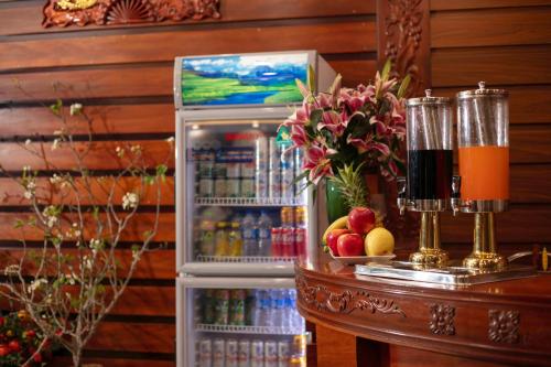 a refrigerator full of drinks and fruit on a table at Airport Classic Hotel 2 in Sóc Sơn