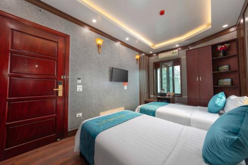 a bedroom with two beds and a tv in it at Airport Classic Hotel 2 in Sóc Sơn