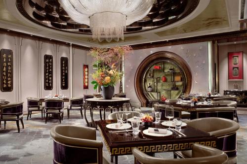 a restaurant with tables and chairs and a chandelier at The St. Regis on the Bund, Shanghai in Shanghai