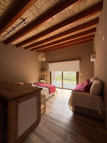 a bedroom with two beds and a large window at Moderna Cabaña en Purmamarca in Purmamarca