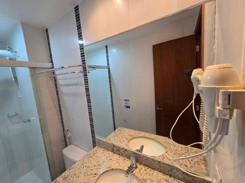 a bathroom with a sink and a mirror at Apartamentos em Rio Quente com maravilhosa área de lazer e excelente localização in Rio Quente
