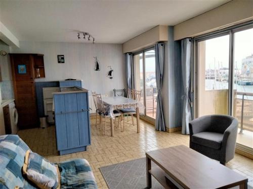 un salon avec un canapé et une table dans l'établissement Charmant T2 avec Balcon au Cœur des Sables d'Olonne, 150m du Centre, Ascenseur, Équipements Modernes - FR-1-331-213, à Les Sables-dʼOlonne