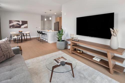a living room with a large flat screen tv on a wall at Luxury Apartments by Hyatus Boston Somerville in Somerville