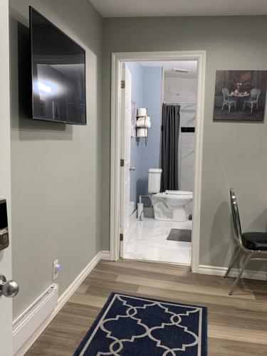 a bathroom with a toilet and a television on the wall at 2BR House - Quiet Getaway in Windsor