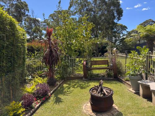 a garden with a bench in the middle at Bilpin Studio Getaway in Bilpin