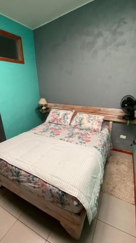 a bedroom with a bed with a wooden headboard at Hostal Boutique F in El Quisco
