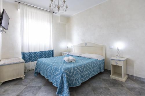 a bedroom with a bed with a blue bedspread at Morpheo Rooms in Alghero