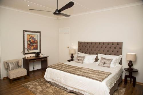 a bedroom with a large bed and a chair at Barney Barnato in Kimberley
