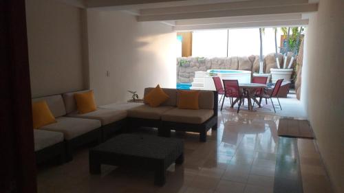 a living room with a couch and a table and chairs at Marbella 25 in Acapulco