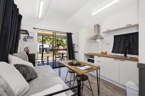 a kitchen and living room with a couch and a table at Townsville Lakes Holiday Park in Townsville