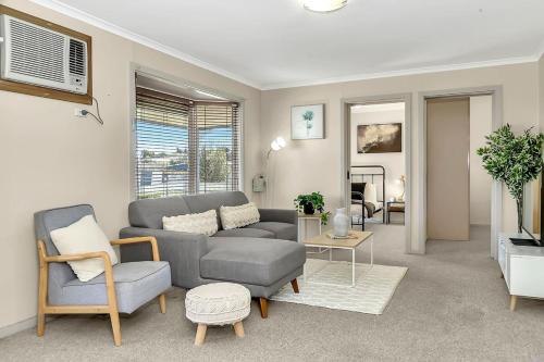 a living room with a couch and a chair at Charming Coastal Cottage-Steps Away from the Beach in Aldinga Beach
