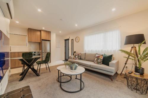 a living room with a couch and a table at Bright City Base - 1Bed Kitchen Outdoor Space in Christchurch
