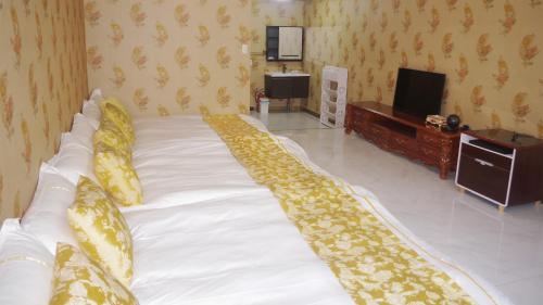 a large white bed in a room with a tv at ホテル　ロモサ in Minakami