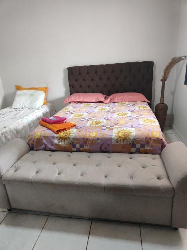 a bed with pink pillows on it in a bedroom at Suite tripla Pousada Canto dos Pássaros in Cianorte