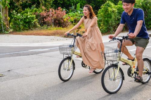 a man and a woman riding bikes down the street at 心邸 kukuru in Nakijin