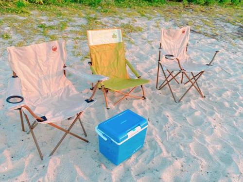 two folding chairs and a cooler on the beach at 心邸 kukuru in Nakijin