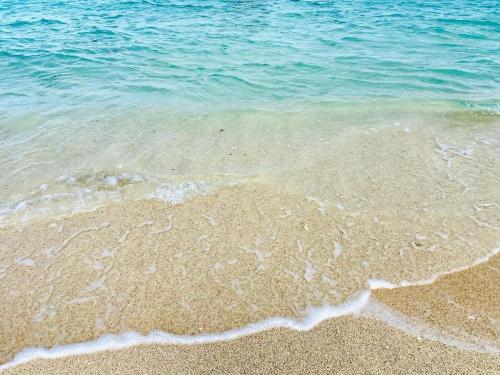 a close up of the sand and water on a beach at 心邸 kukuru in Nakijin