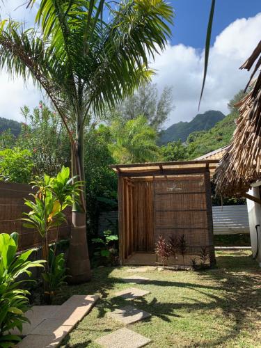 einen Garten mit einem Tor und einer Palme in der Unterkunft FARE TEMANEA in Papetoai