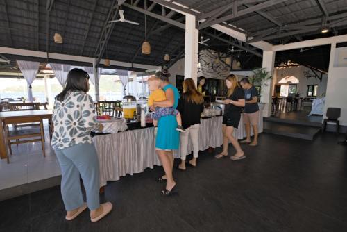 Un groupe de personnes autour d'un stand de nourriture dans l'établissement Oceana Dive Resort, à Gorontalo