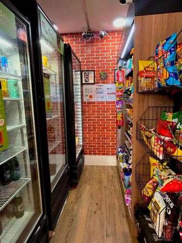 a grocery store aisle with a brick wall at Apartamento aconchegante e moderno com varanda na Rua Guaicurus in Sao Paulo