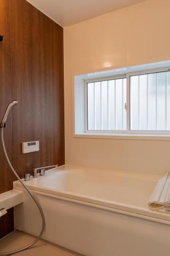 eine Badewanne in einem Badezimmer mit Fenster in der Unterkunft Kumano Kodo Private House-CHILL HOUSE-Nachikatsuura in Nachikatsuura