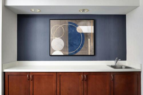 ストックトンにあるCourtyard by Marriott Stocktonのシンクと壁に絵が飾られたキッチン