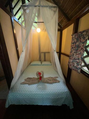 a room with a bed with a dress on it at Alby Lodge Cahuita in Cahuita