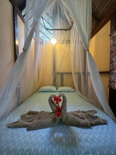 a bedroom with a bed with a robe on it at Alby Lodge Cahuita in Cahuita