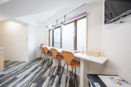 a row of bar stools in a room with windows at Vacation Inn Omorikaigan 1 in Tokyo