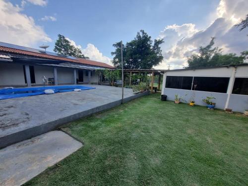 a backyard of a house with a swimming pool at Chácara Cantinho dos Sonhos in Chapada dos Guimarães