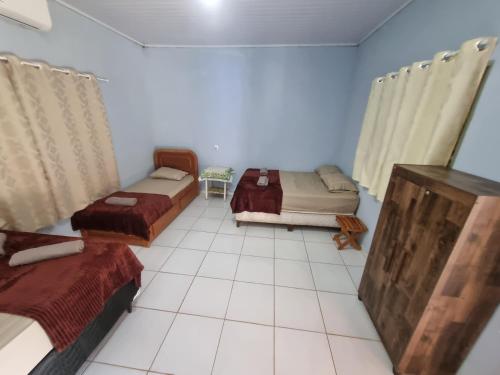 a room with three beds and a tiled floor at Chácara Cantinho dos Sonhos in Chapada dos Guimarães