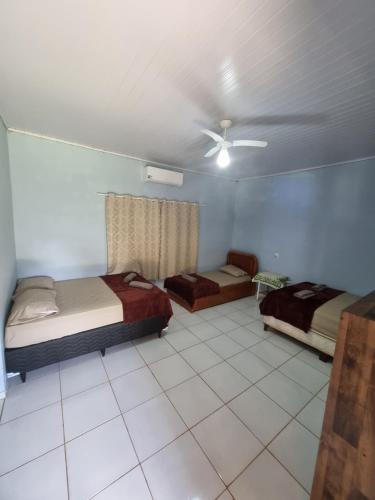 a bedroom with two beds and a ceiling fan at Chácara Cantinho dos Sonhos in Chapada dos Guimarães