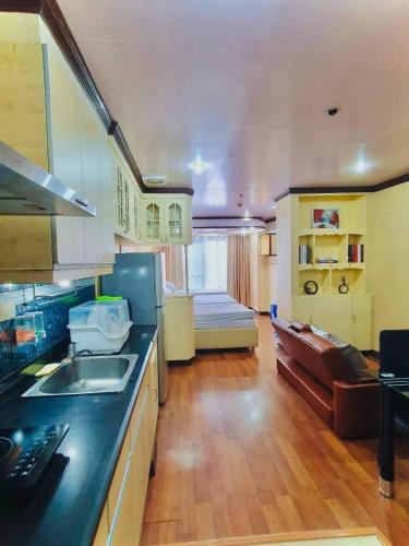a kitchen with a sink and a couch in a room at Burnham Unit 504 Baguio Condo Transient by Dei Gratia in Baguio