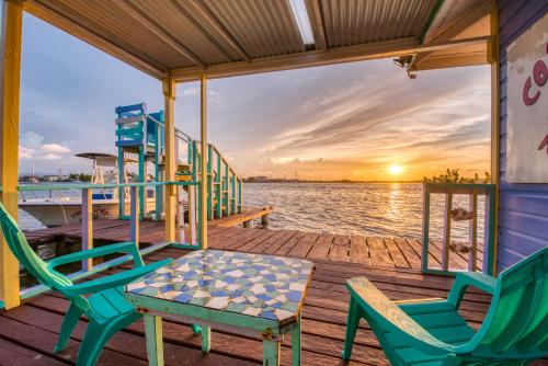 a dock with chairs and a table on a boat at Cosmic Crab Resort in Bocas del Toro