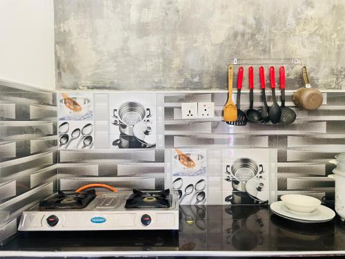 a kitchen with a counter with a stove and utensils at Zen Zone in Weligama