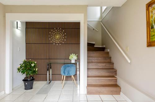 a staircase in a house with a blue chair at Oak Park House in Vancouver in Vancouver