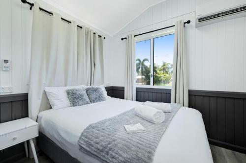 a bedroom with a white bed and a window at Townsville Lakes Holiday Park in Townsville