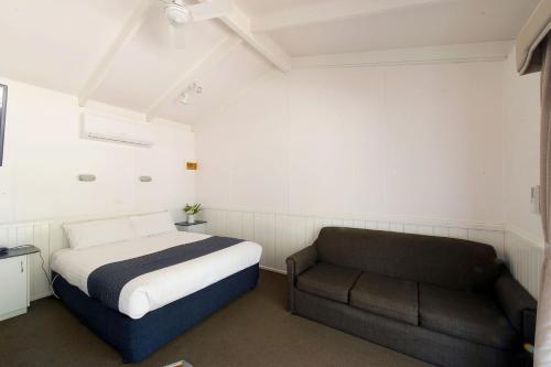a bedroom with a bed and a chair at BIG4 Riverside Swan Hill in Swan Hill