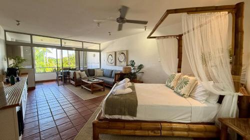 a bedroom with a bed and a living room at Bella Vista in Port Douglas