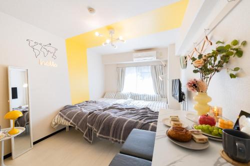a bedroom with a bed and a table with food on it at Felizstay Tokyo in Tokyo