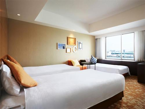 a hotel room with two beds and a window at Hotel Universal Port in Osaka